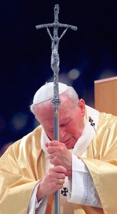 Pope John Paul II rests his forehead against the papal crucifix in a moment of reflection.