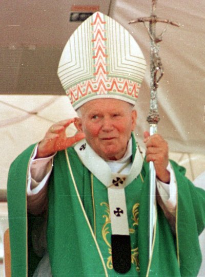 Pope John Paul II holds the papal staff while wearing green vestments and a mitre.