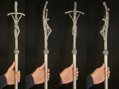 Four sequential angles showing the rotation of the sculpted crucifix replica on a staff.