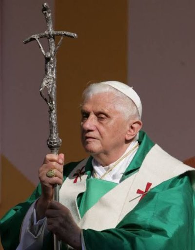 Pope Benedict XVI carries the silver papal ferula during a formal liturgical service.