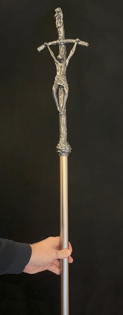 The sculpted crucifix replica mounted securely atop an extended silver aluminum pole.