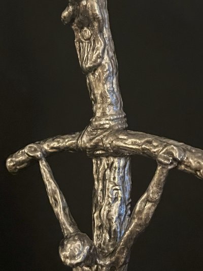 Extreme close-up of the bent crossbar and corpus highlighting the detailed surface texture.