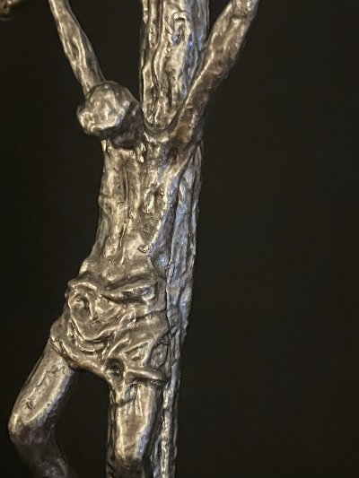 Close-up of the lower torso and legs of the sculpted figure on the papal crucifix.