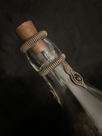 High-angle detail of the tapered glass neck, dual rings, and fitted cork topper.