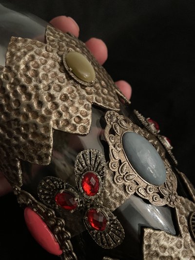Angled mid-section view showing the distribution of cabochons across the bronze-colored casing.