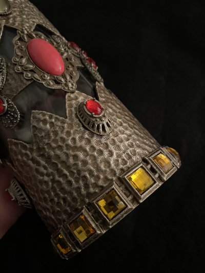 Close-up of the bottle's lower edge highlighting the faceted yellow rectangular stones.