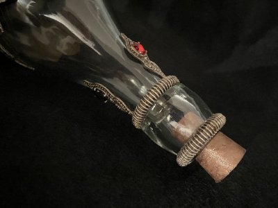 Close-up lateral view of the glass neck, ribbed rings, and inserted cork stopper.