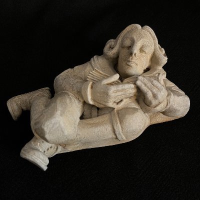 High-angle full view of the reconstituted limestone book scholar replica.
