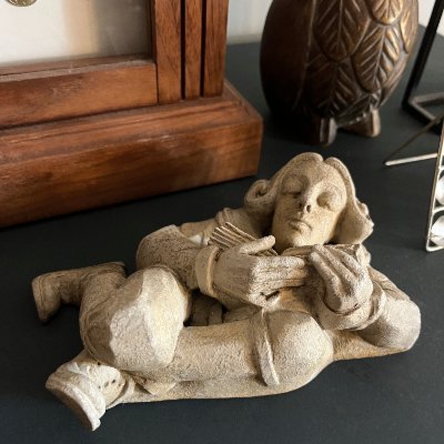 Replica Davenport scholar sculpture displayed on a wooden desktop surface.