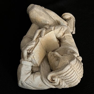 Top-down perspective showing the curvature of the gothic scholar's back and head.