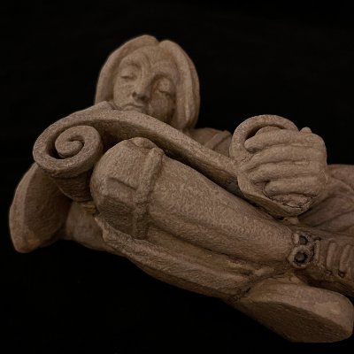 Low-angle perspective looking up from the crossed feet of the scroll reader figure.