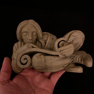 The limestone scroll reader replica held in a hand to demonstrate relative scale.