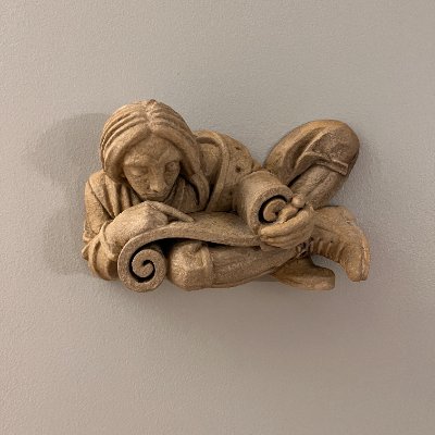 Frontal view of the sculpture mounted vertically on a light-colored interior wall.