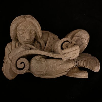 Frontal view of the reconstituted limestone scroll reader replica on a dark background.