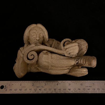The composite limestone replica measured against a ruler documenting its 7-inch width.