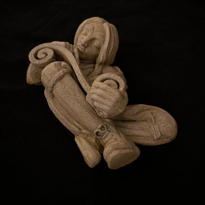 Elevated angled view highlighting the crossed legs and scroll of the scholar figure.