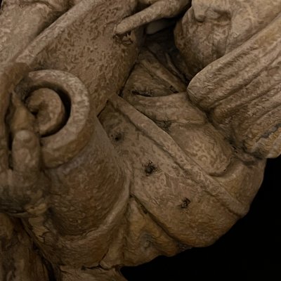 Close-up detail of the rolled scroll finial and the textured limestone composite.