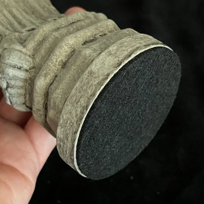 The underside of the heavy stone sculpture revealing the protective black felt bottom.