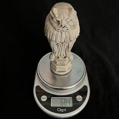 The Yale owl sculpture displayed on a digital scale documenting its 685-gram weight.