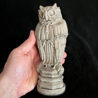 The 8-inch tall Yale Sterling Law Building owl replica held in a hand to demonstrate scale.