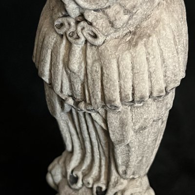 Close-up of the owl's midsection highlighting the intricate carving of the judge's robe.
