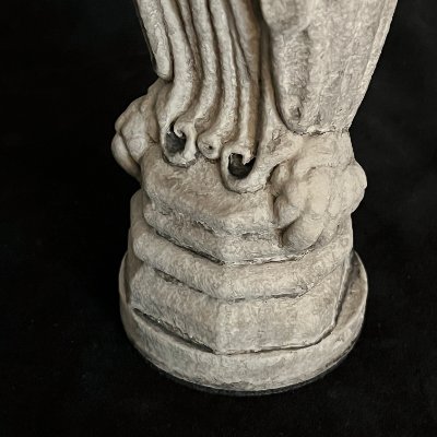 Detailed view of the sculpted talons grasping the heavy stone base of the owl replica.